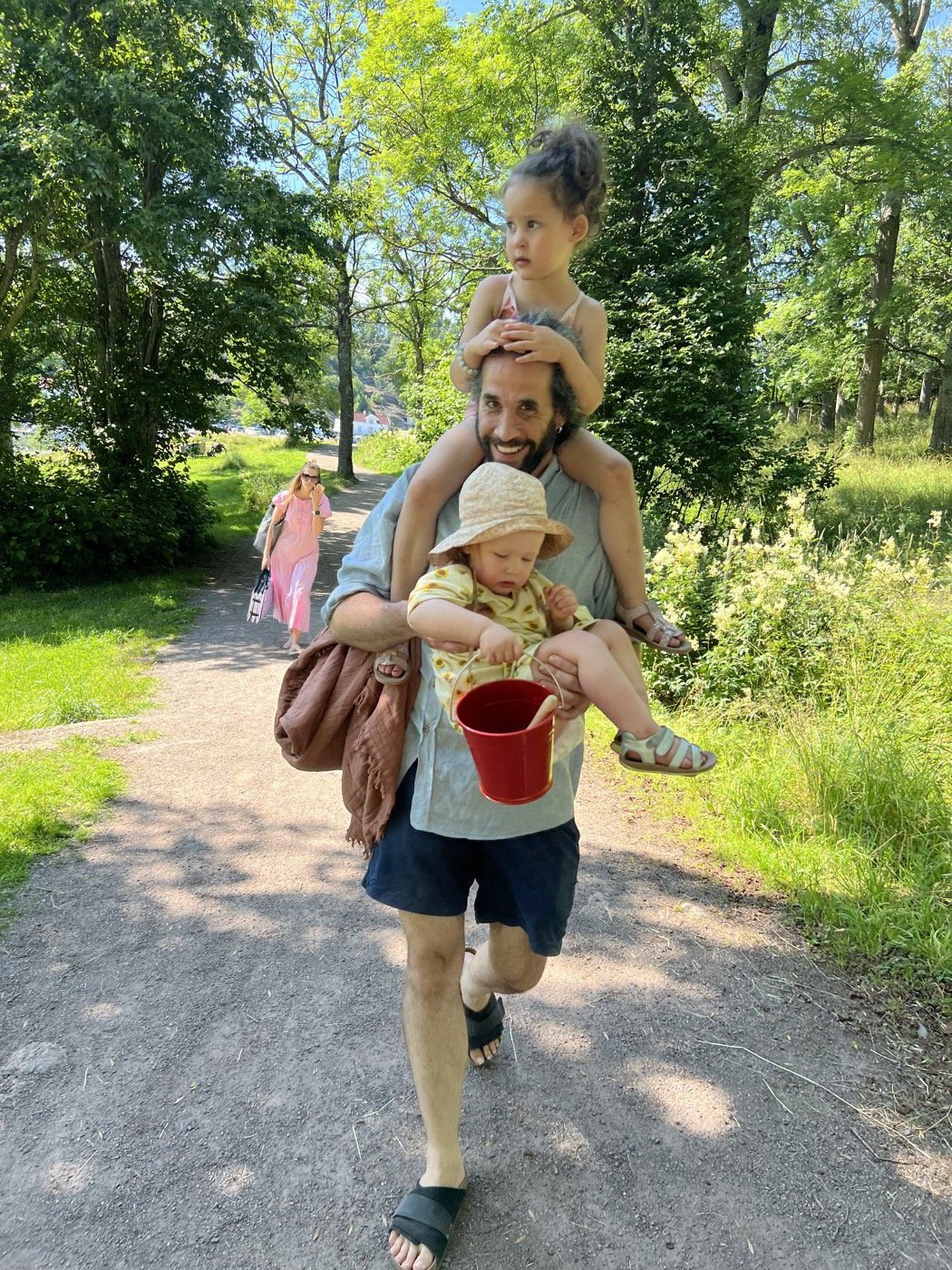 Jonatan carrying both kids in the park