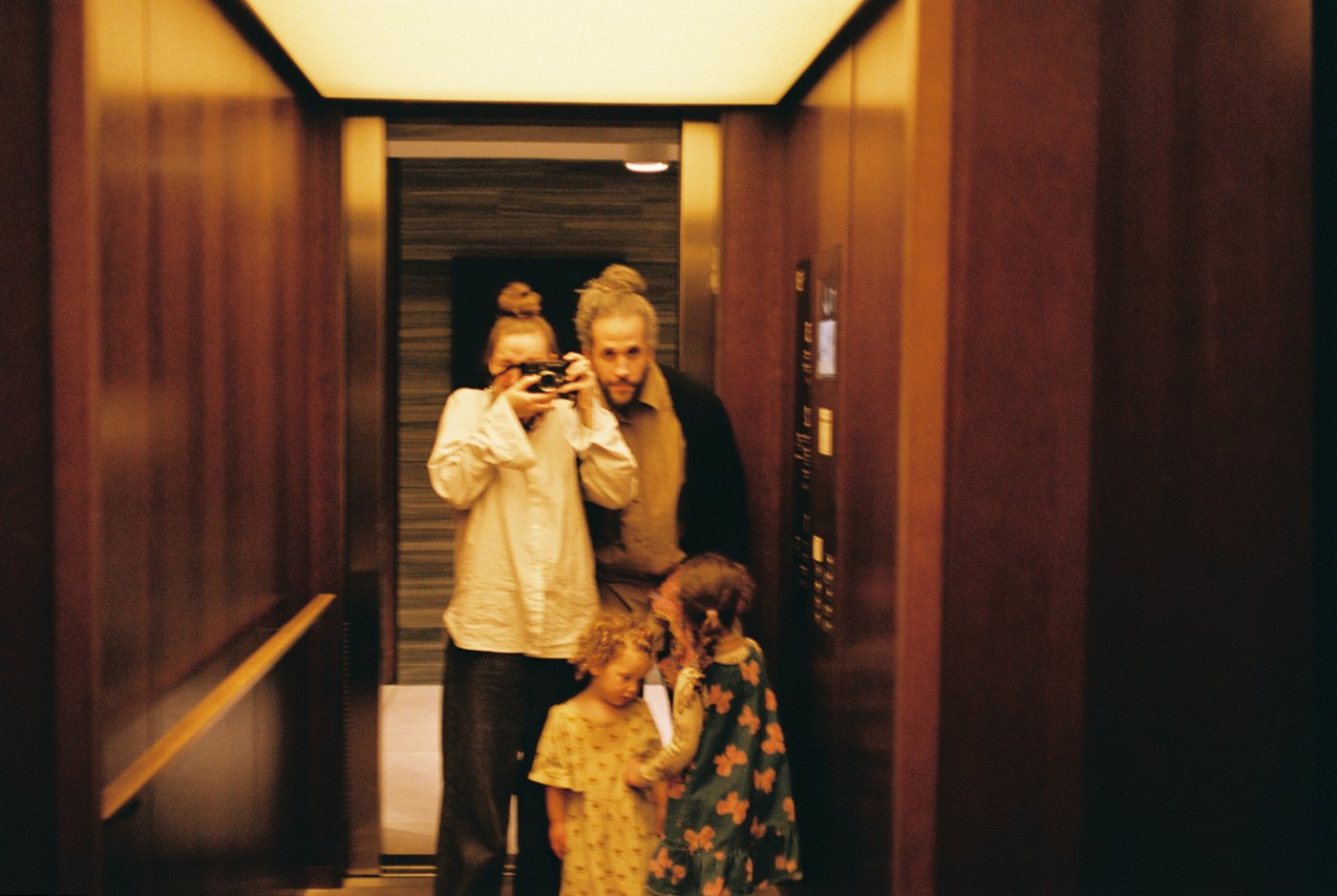 All four of us in a golden elevator mirror